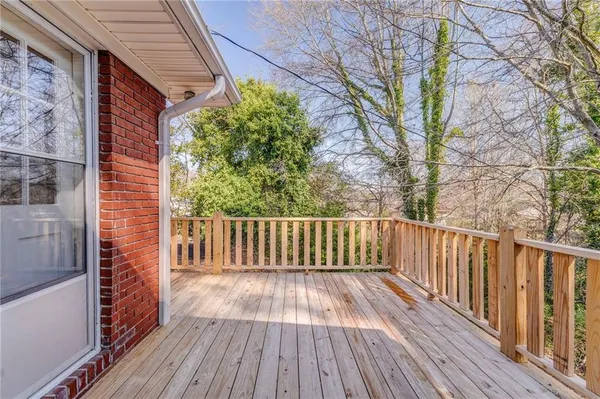 a balcony with wooden floor and trees