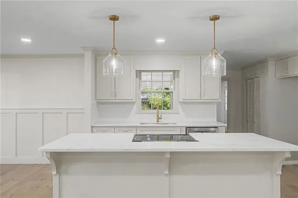 a kitchen with a sink a window and wooden floor