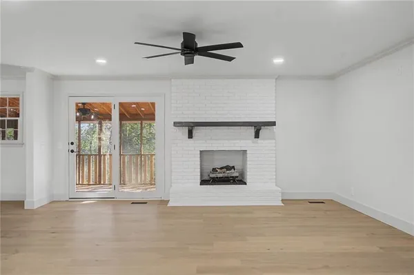 a view of an empty room with a fireplace and a window
