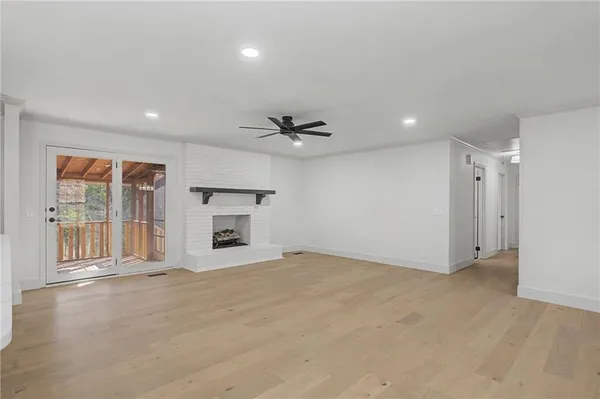a view of an empty room with a fireplace and a window