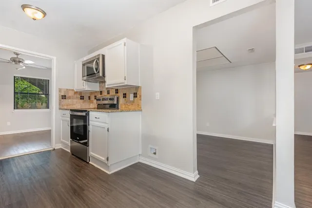 a kitchen with a refrigerator and a stove top oven
