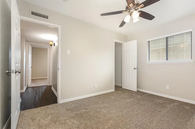 a bedroom with a bed and a chandelier fan