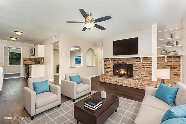 a living room with furniture a flat screen tv and a fireplace