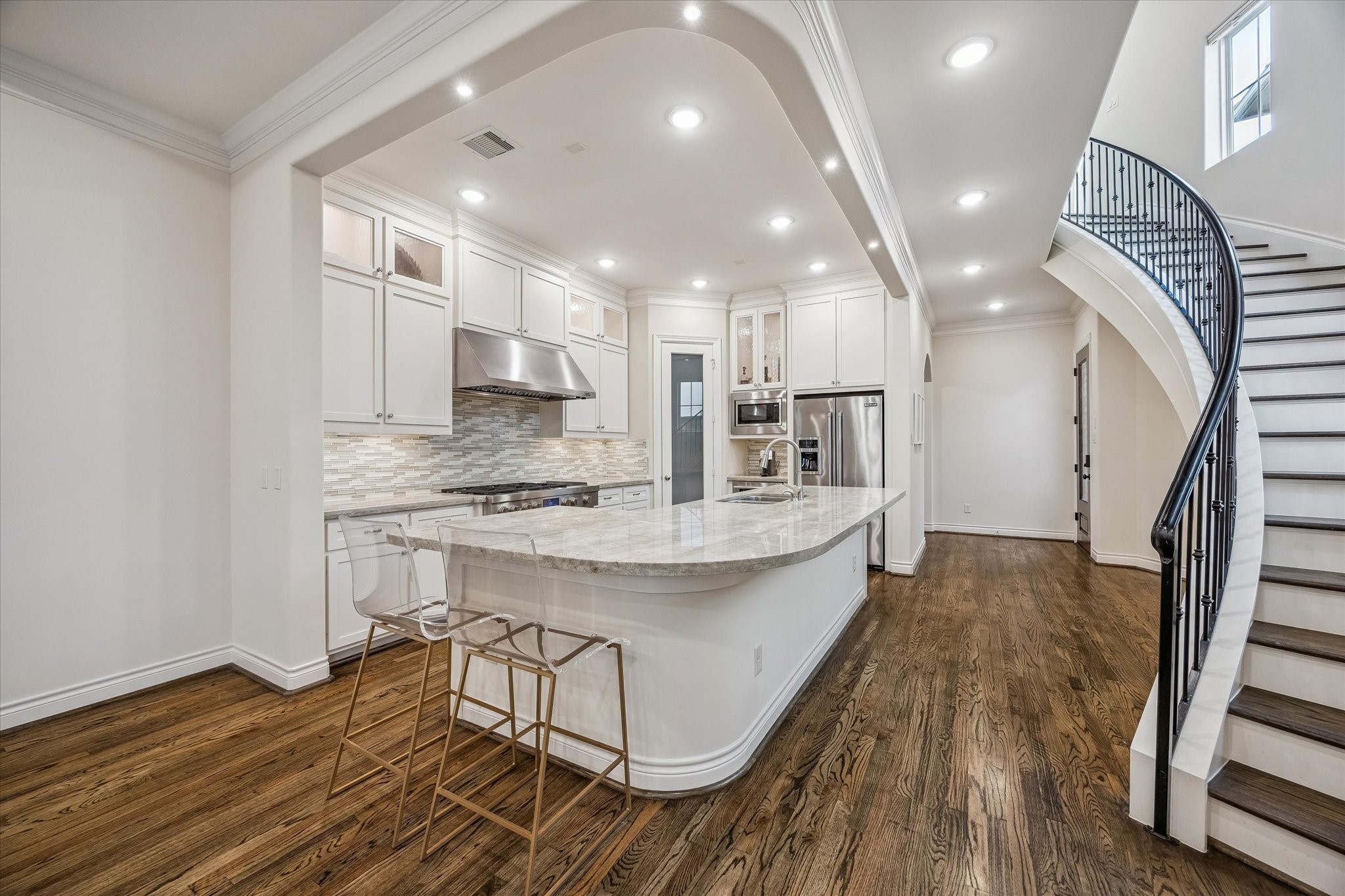 5305 Gibson Street Houston, TX 77007 - Photo 12 of 46 a large kitchen with kitchen island a island a sink wooden floor and stainless steel appliances