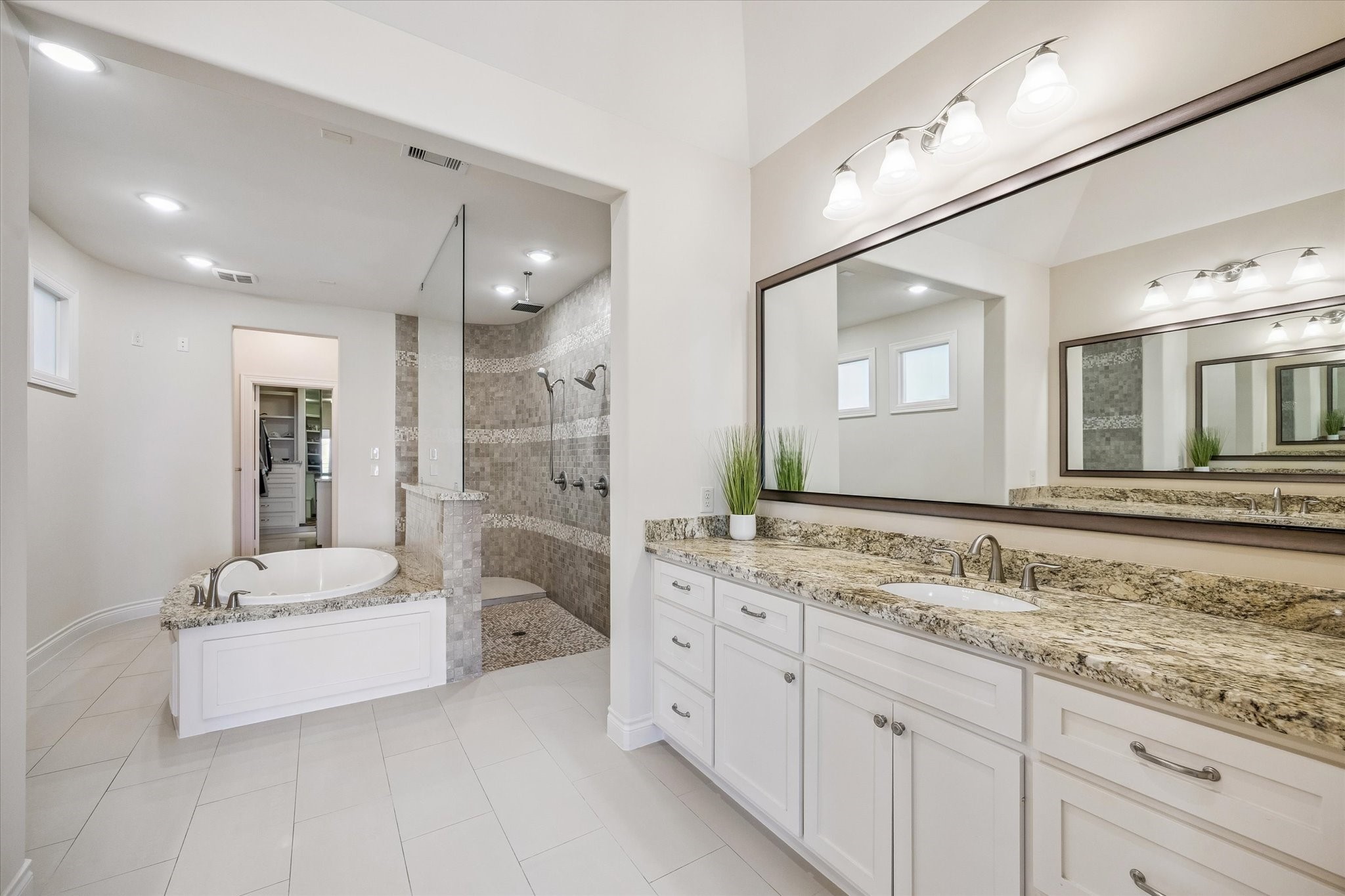 5305 Gibson Street Houston, TX 77007 - Photo 22 of 46 a bathroom with a sink double vanity granite tub shower and a mirror