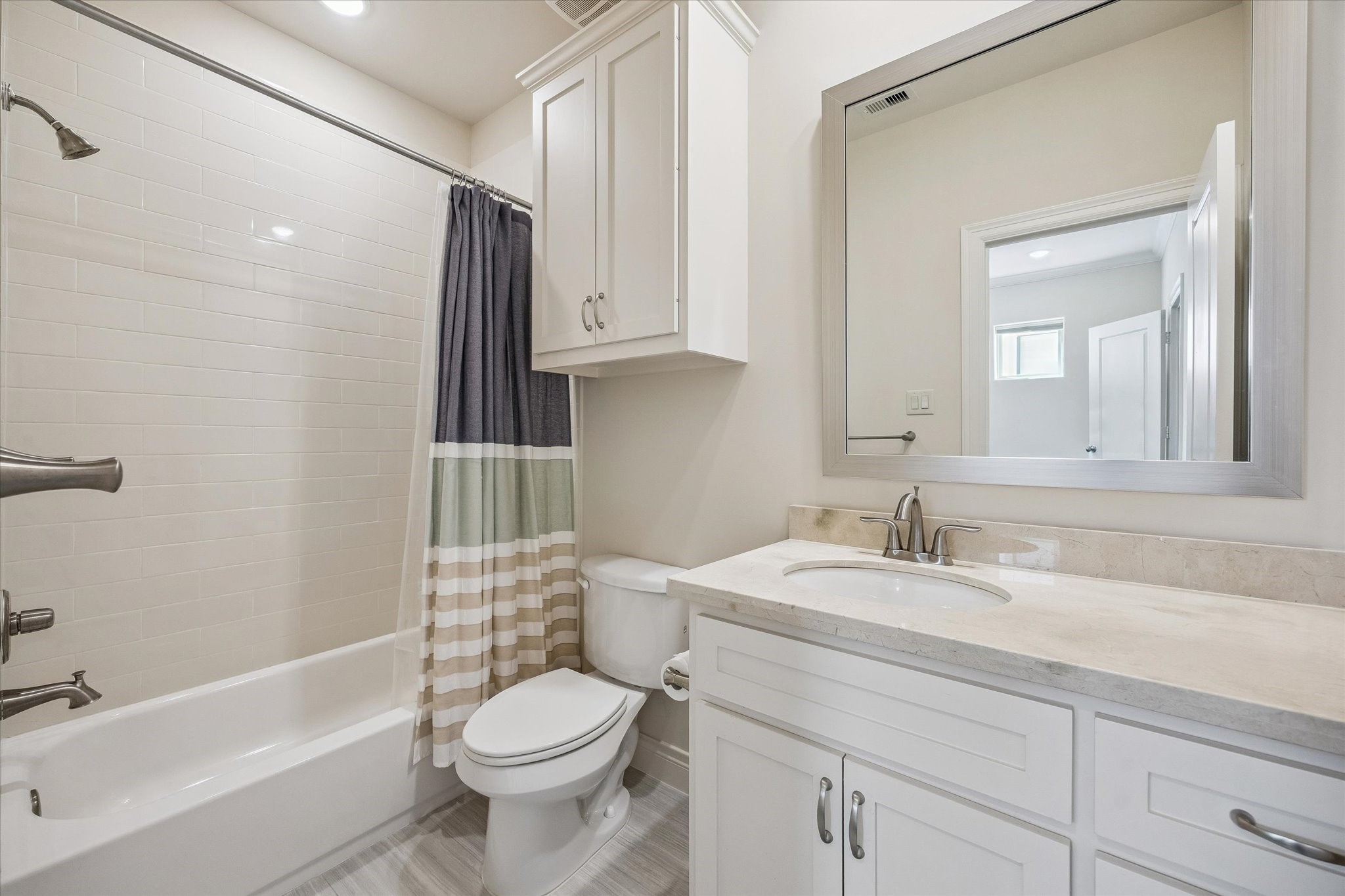 5305 Gibson Street Houston, TX 77007 - Photo 29 of 46 a bathroom with a granite countertop toilet sink and mirror
