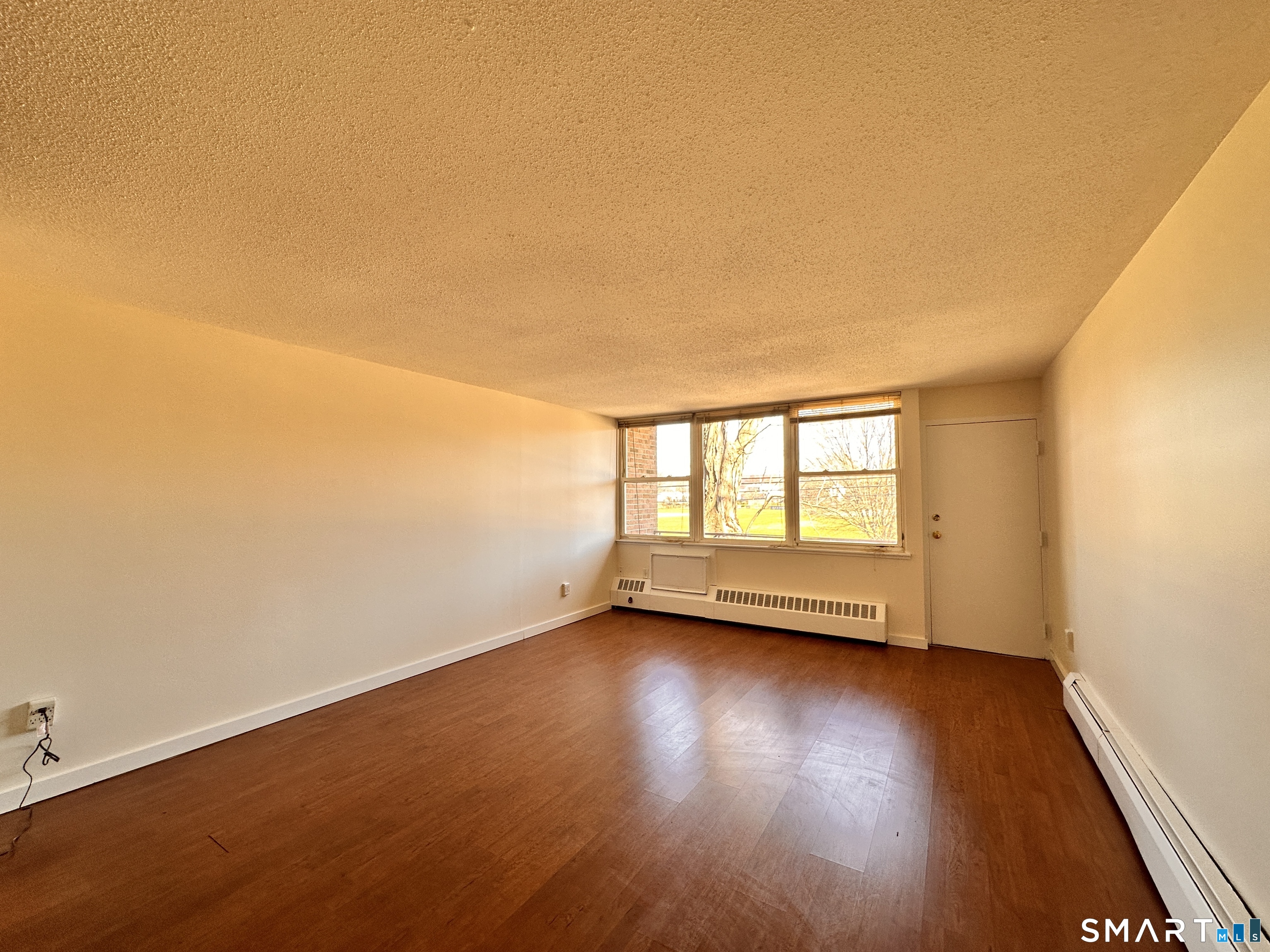 25 Ellsworth Street, Unit 17 Bridgeport, CT 06605 - Photo 5 of 30 an empty room with wooden floor and windows