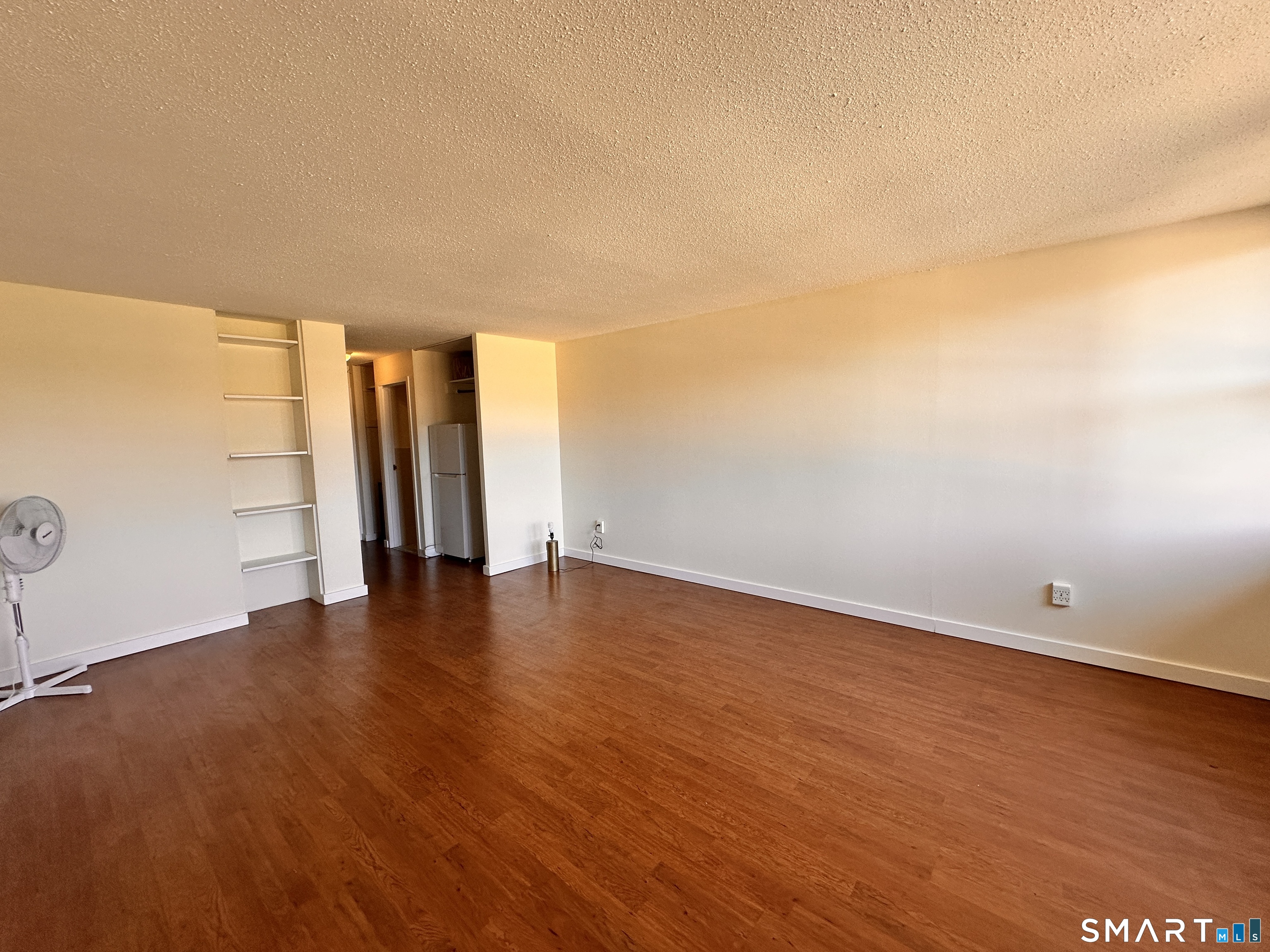 25 Ellsworth Street, Unit 17 Bridgeport, CT 06605 - Photo 6 of 30 an empty room with wooden floor and windows with curtains