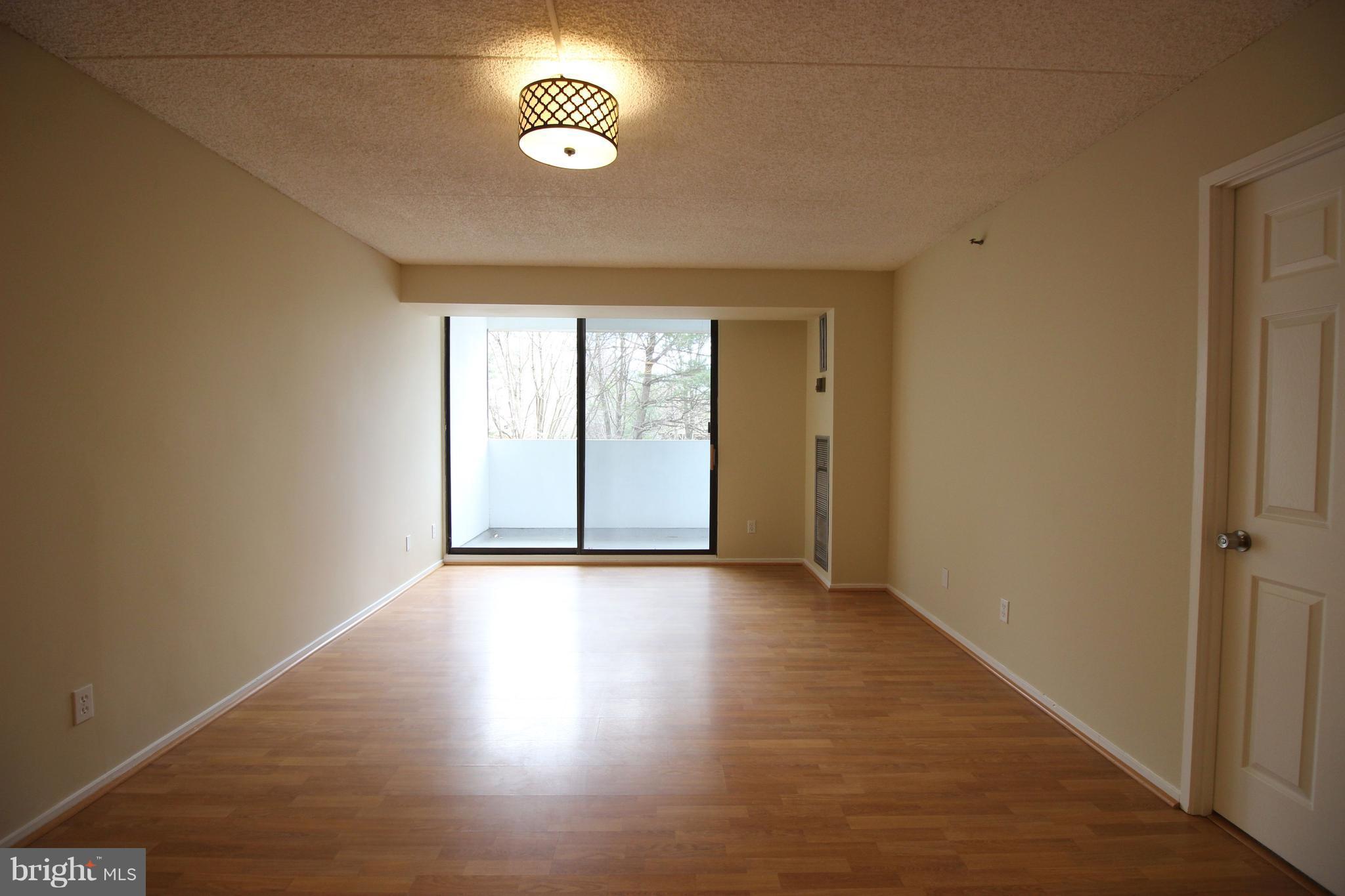 5911 Edsall Road, Unit 405 Alexandria, VA 22304 - Photo 4 of 23 an empty room with wooden floor and windows