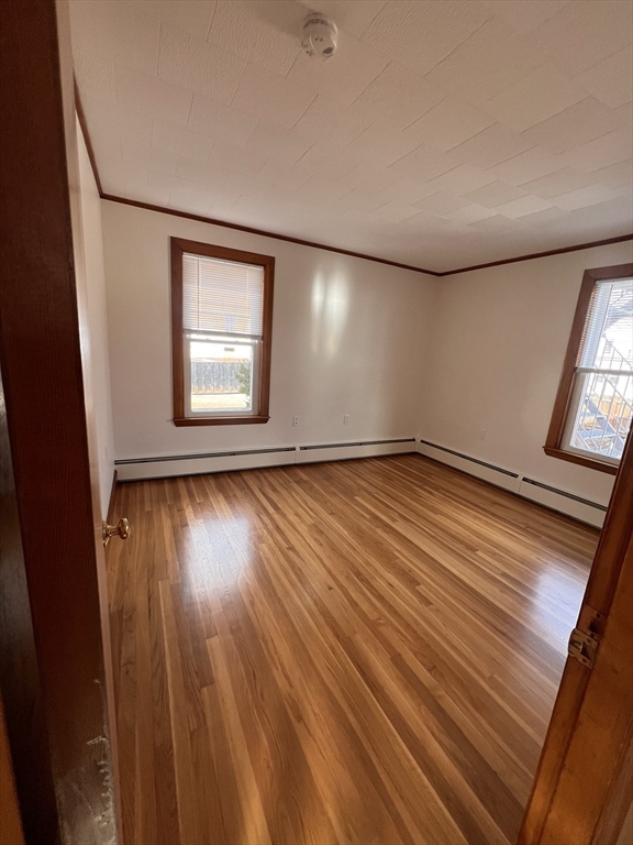 24 Proctor Street, Unit 2 Peabody, MA 01960 - Photo 12 of 19 an empty room with wooden floor and windows