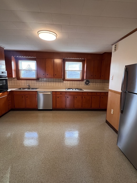 24 Proctor Street, Unit 2 Peabody, MA 01960 - Photo 4 of 19 a kitchen with stainless steel appliances granite countertop a sink and a refrigerator