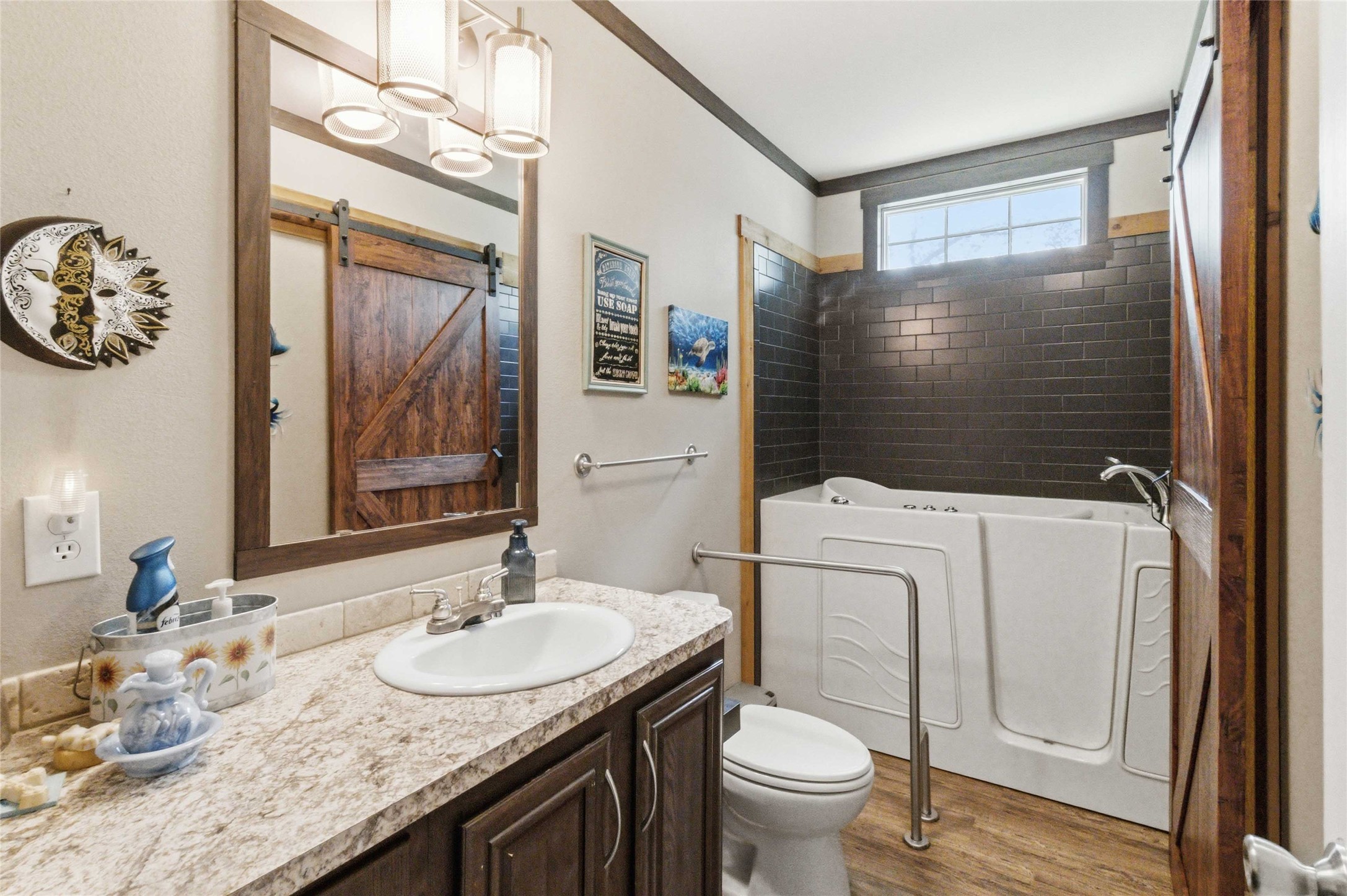 7921 Vista Ranch Road Smithville, TX 78957 - Photo 13 of 39 A well-appointed bath features rich wood flooring, a vanity with a full mirror, and a modern walk-in tub.
