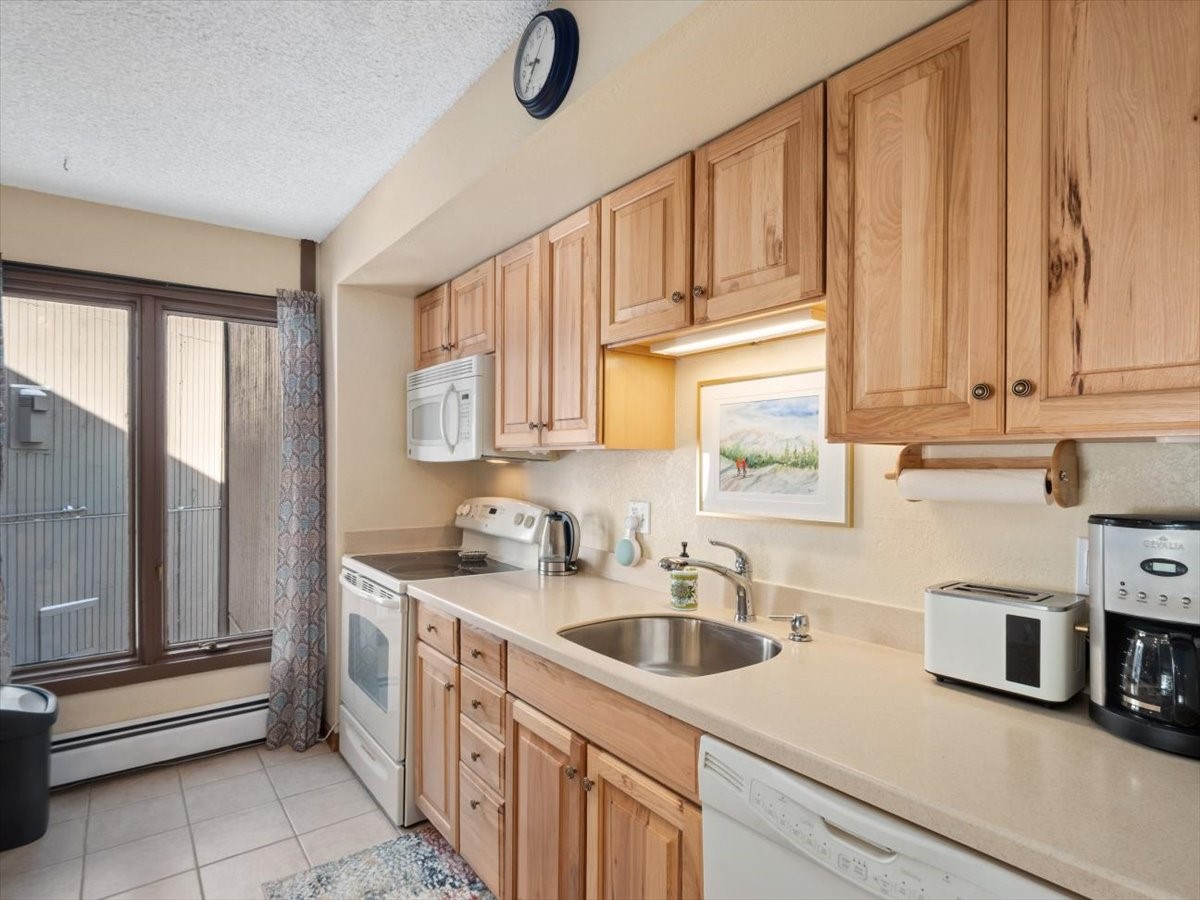 1161 Ski Hill Road, Unit 141 Breckenridge, CO 80424 - Photo 11 of 22 a kitchen with stainless steel appliances granite countertop a sink a stove and cabinets