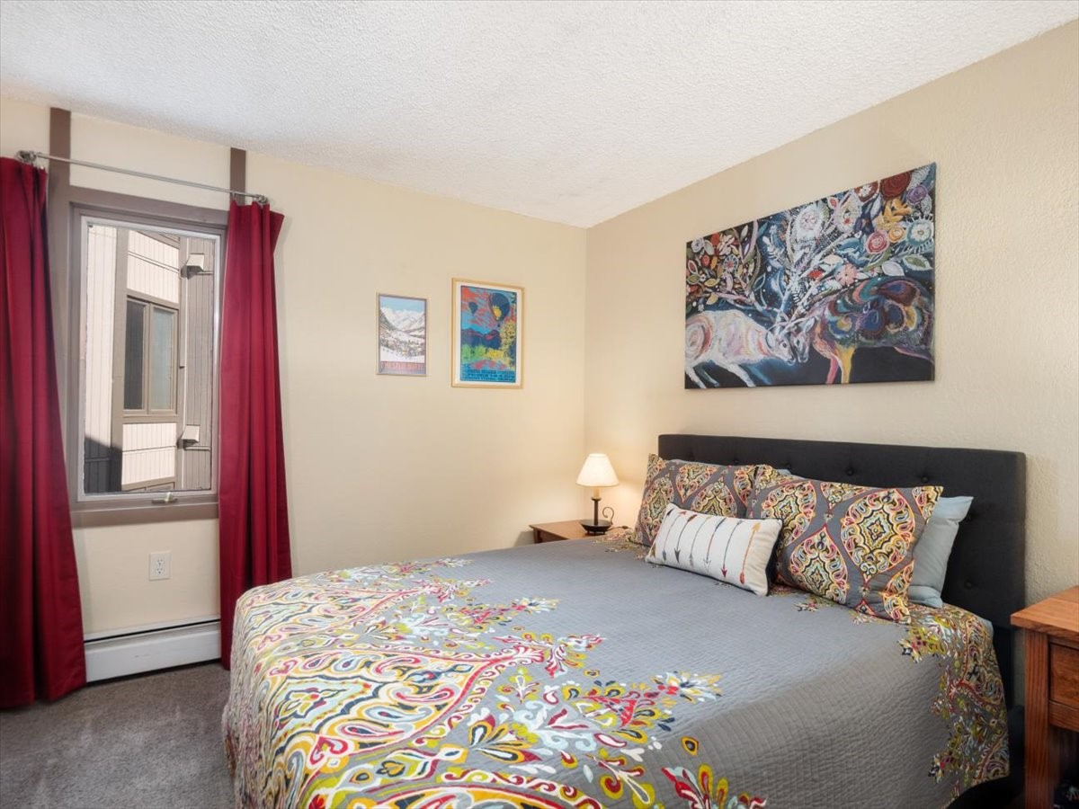 1161 Ski Hill Road, Unit 141 Breckenridge, CO 80424 - Photo 13 of 22 a bedroom with a bed and a painting on the wall