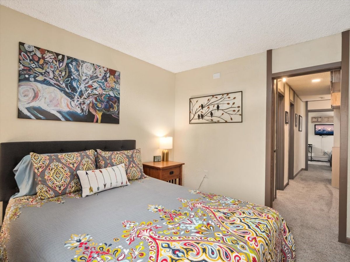 1161 Ski Hill Road, Unit 141 Breckenridge, CO 80424 - Photo 14 of 22 a bedroom with a bed and a painting on the wall