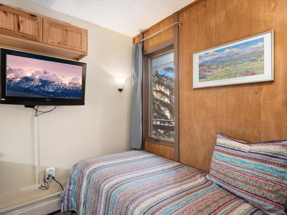 1161 Ski Hill Road, Unit 141 Breckenridge, CO 80424 - Photo 16 of 22 a bedroom with a bed and a flat screen tv