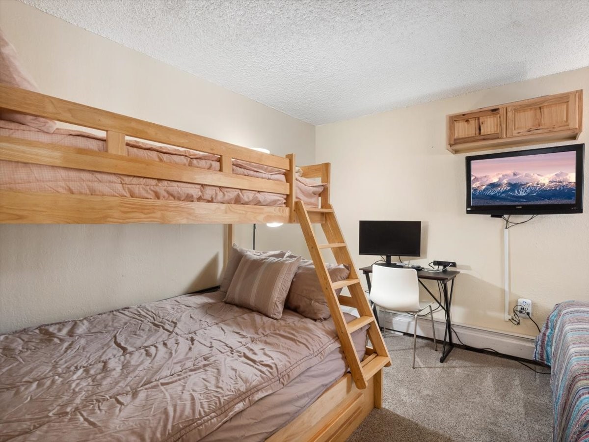 1161 Ski Hill Road, Unit 141 Breckenridge, CO 80424 - Photo 17 of 22 a bedroom with a bed and a flat screen tv