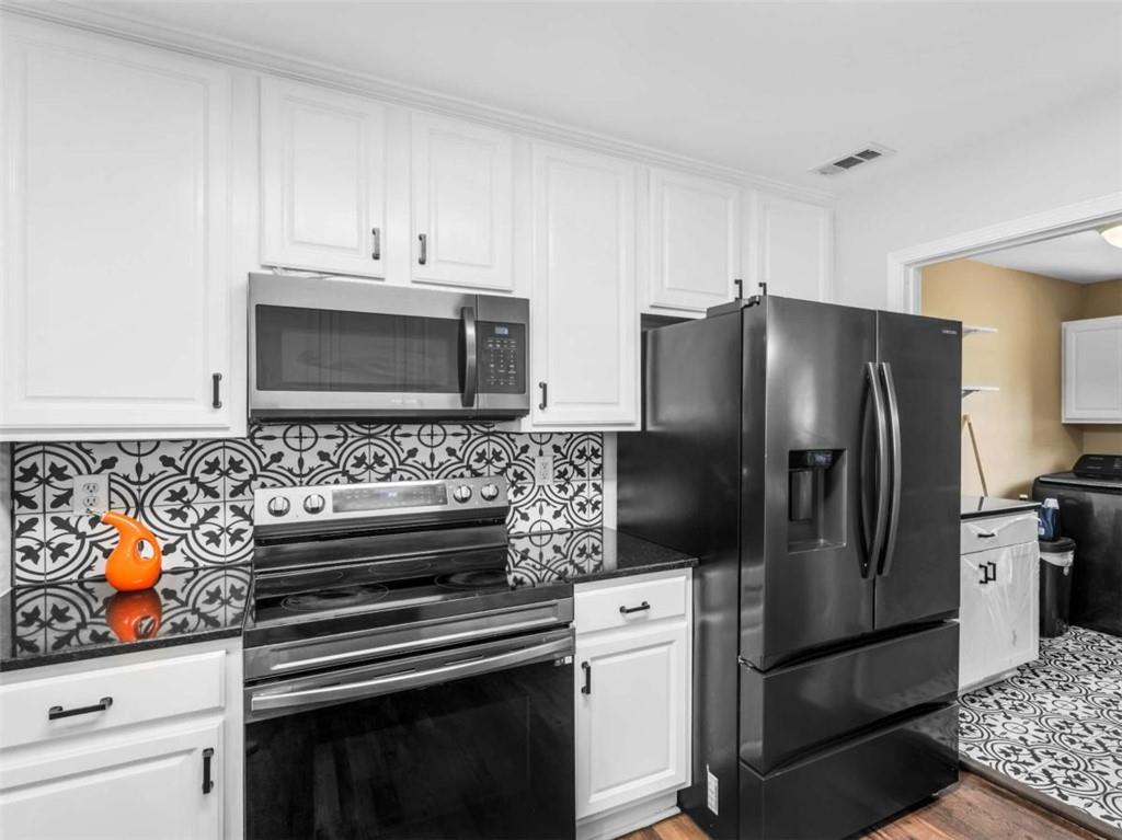 545 Barhams Ridge Drive McDonough, GA 30252 - Photo 20 of 62 a kitchen with stainless steel appliances and chandelier
