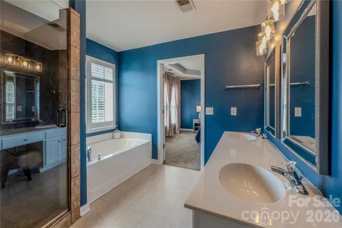 a en suite spacious bathroom with a granite countertop tub sink and glass door