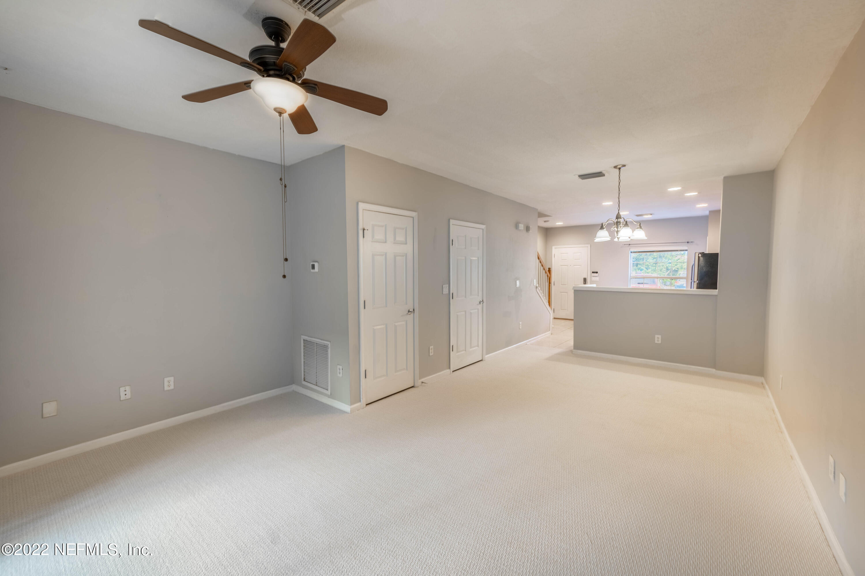 8085 Summerside Circle Jacksonville, FL 32256 - Photo 10 of 21 an empty room with a kitchen and a chandelier fan