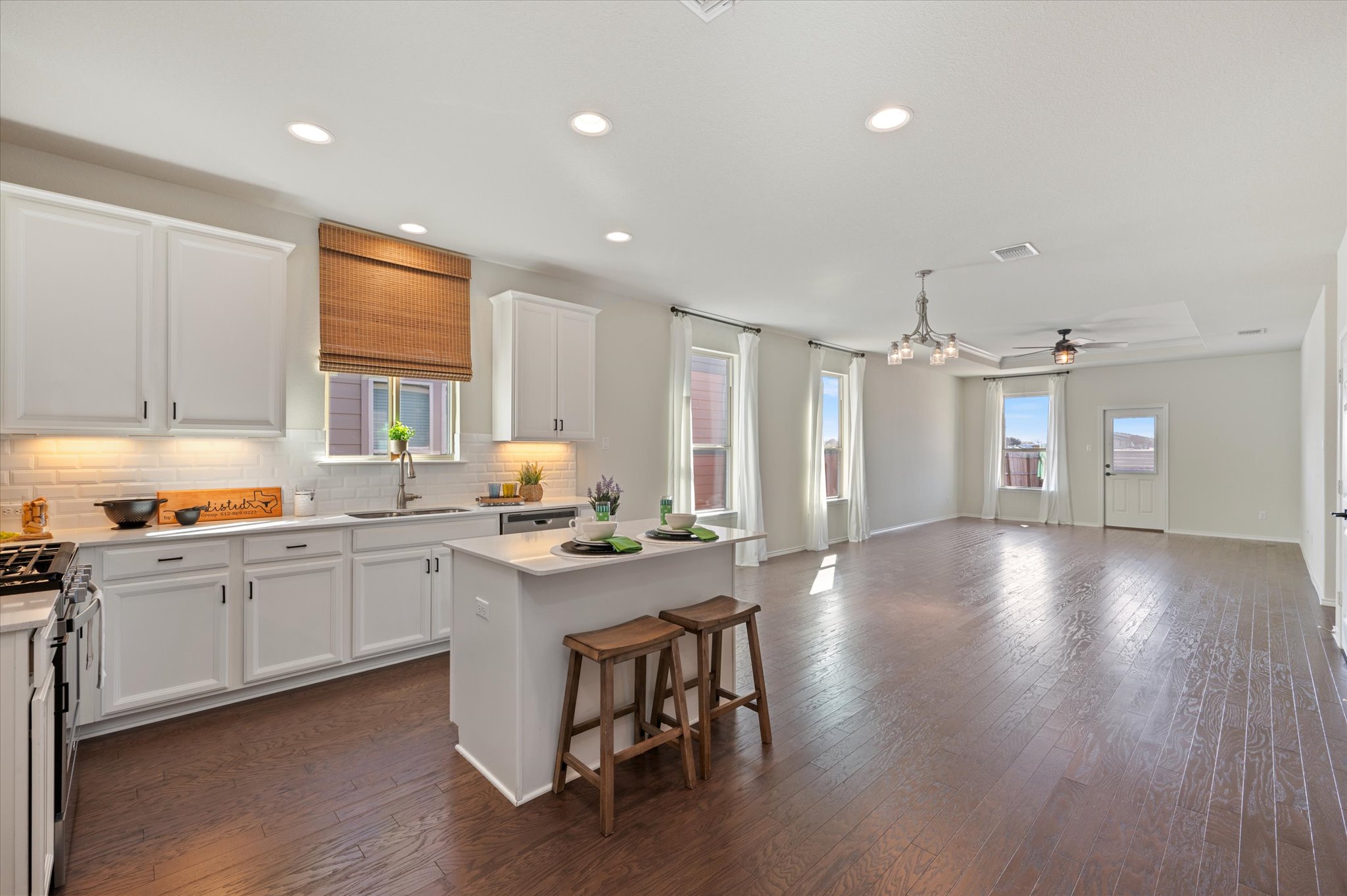 2044 Cliffbrake Way Georgetown, TX 78626 - Photo 11 of 40 Kitchen with white cabinetry, a kitchen island, a breakfast bar, dark wood flooring, and recessed lighting
