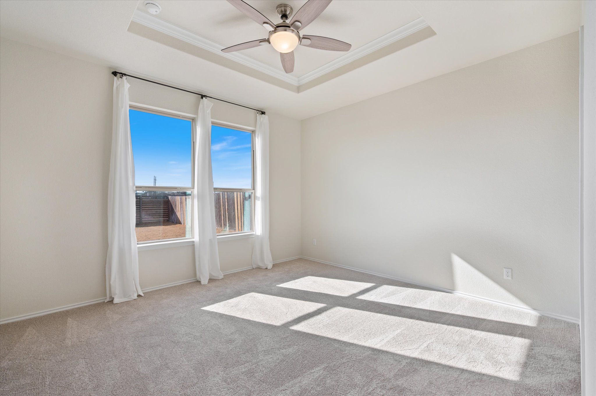 2044 Cliffbrake Way Georgetown, TX 78626 - Photo 25 of 40 Primary Bedroom with large window, carpet and tray ceiling.