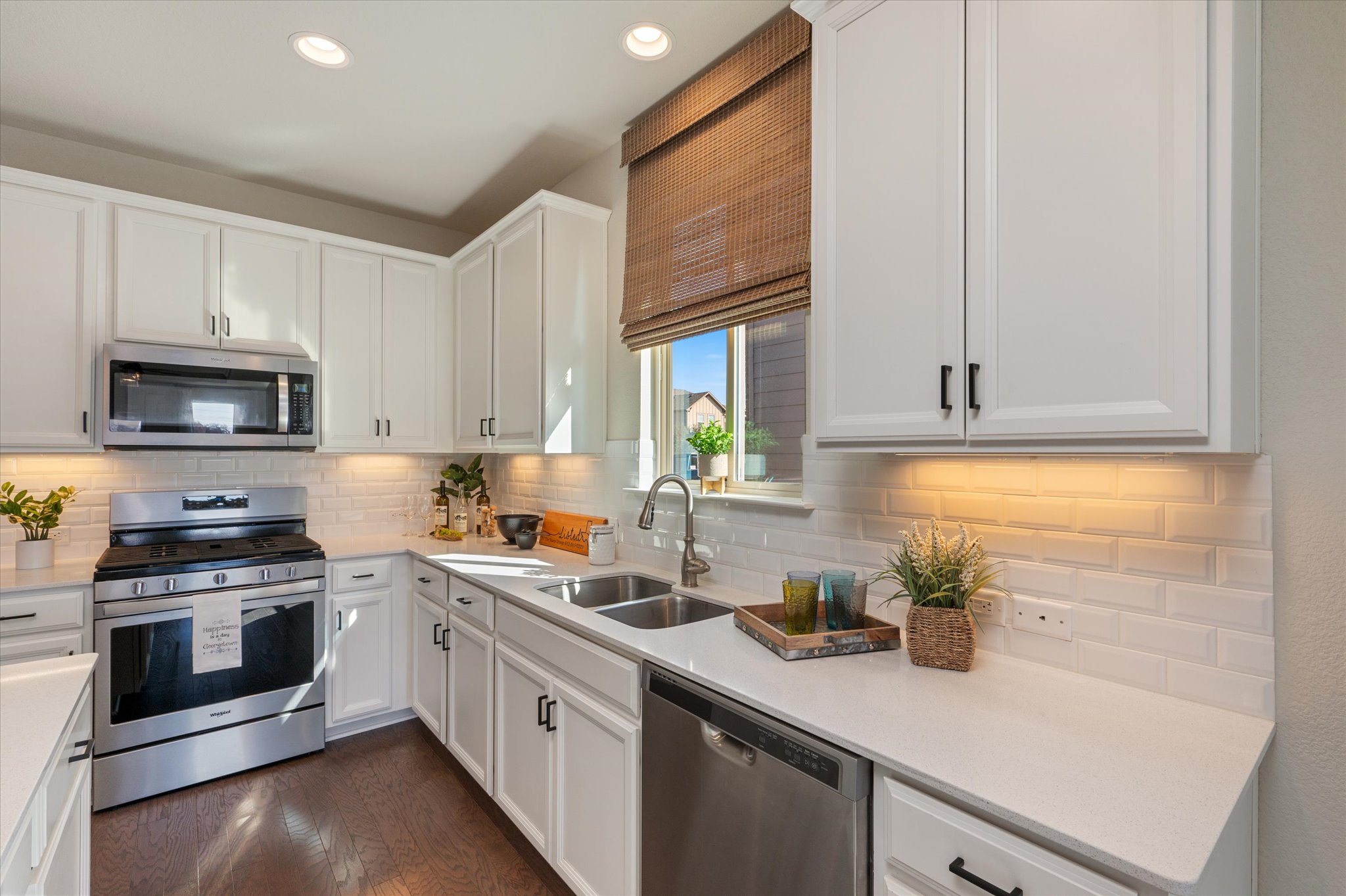 2044 Cliffbrake Way Georgetown, TX 78626 - Photo 8 of 40 Kitchen with stainless steel appliances, white cabinets, recessed lighting, dark wood flooring, and white subway backsplash