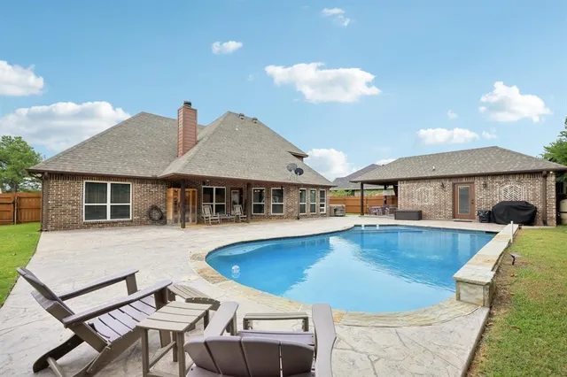 a view of a house with swimming pool and sitting area