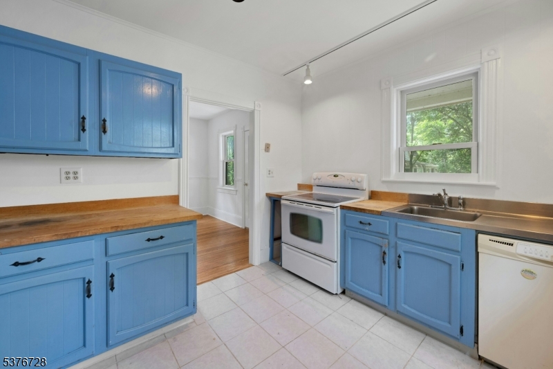 59 Main Street Peapack-Gladstone, NJ 07977 - Photo 11 of 30 a kitchen with granite countertop wooden cabinets stainless steel appliances a sink and a window