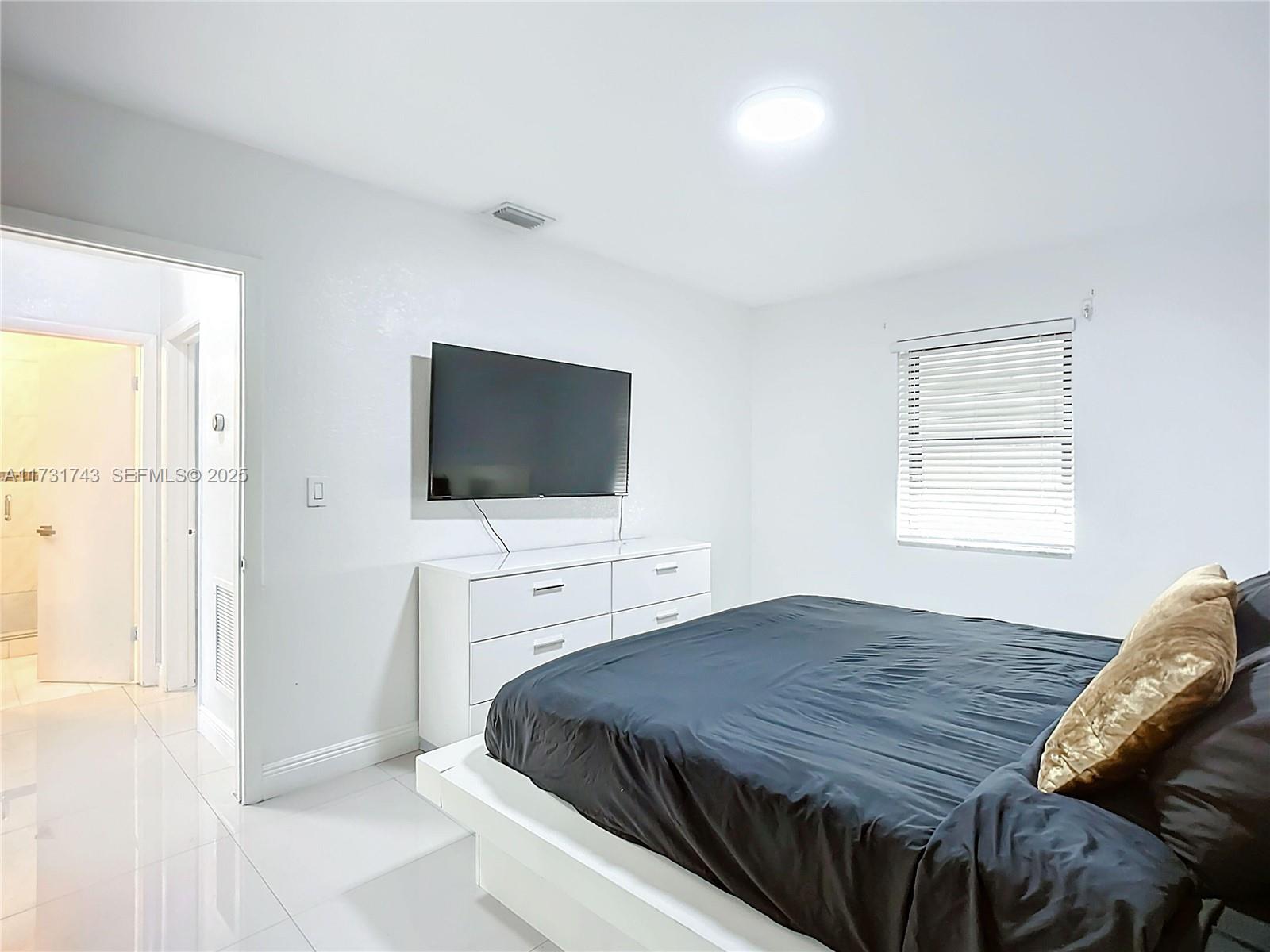 35 Southwest 63rd Court Miami, FL 33144 - Photo 18 of 42 a bedroom with a bed and a flat screen tv