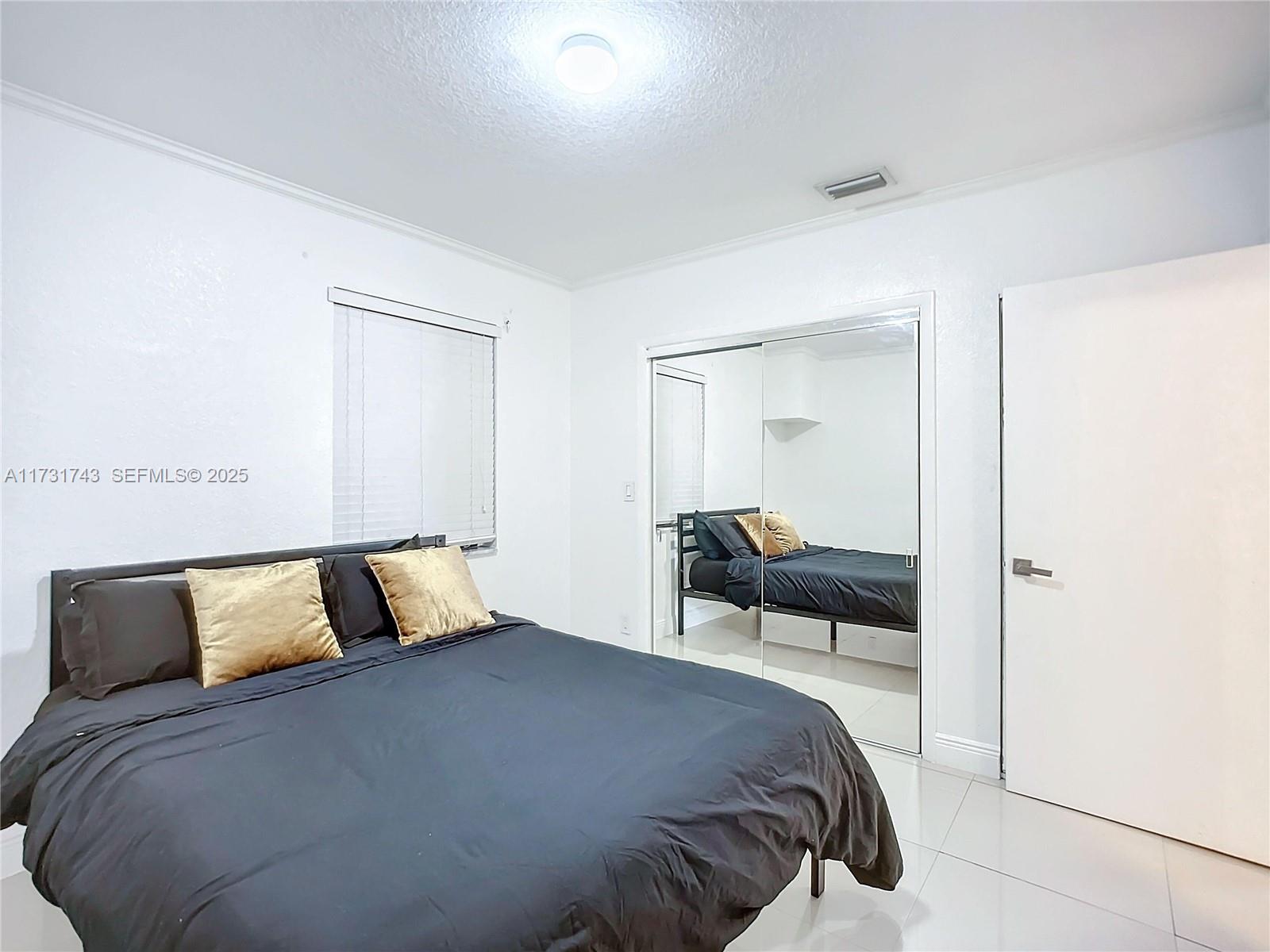 35 Southwest 63rd Court Miami, FL 33144 - Photo 22 of 42 a bedroom with a bed and a night stand