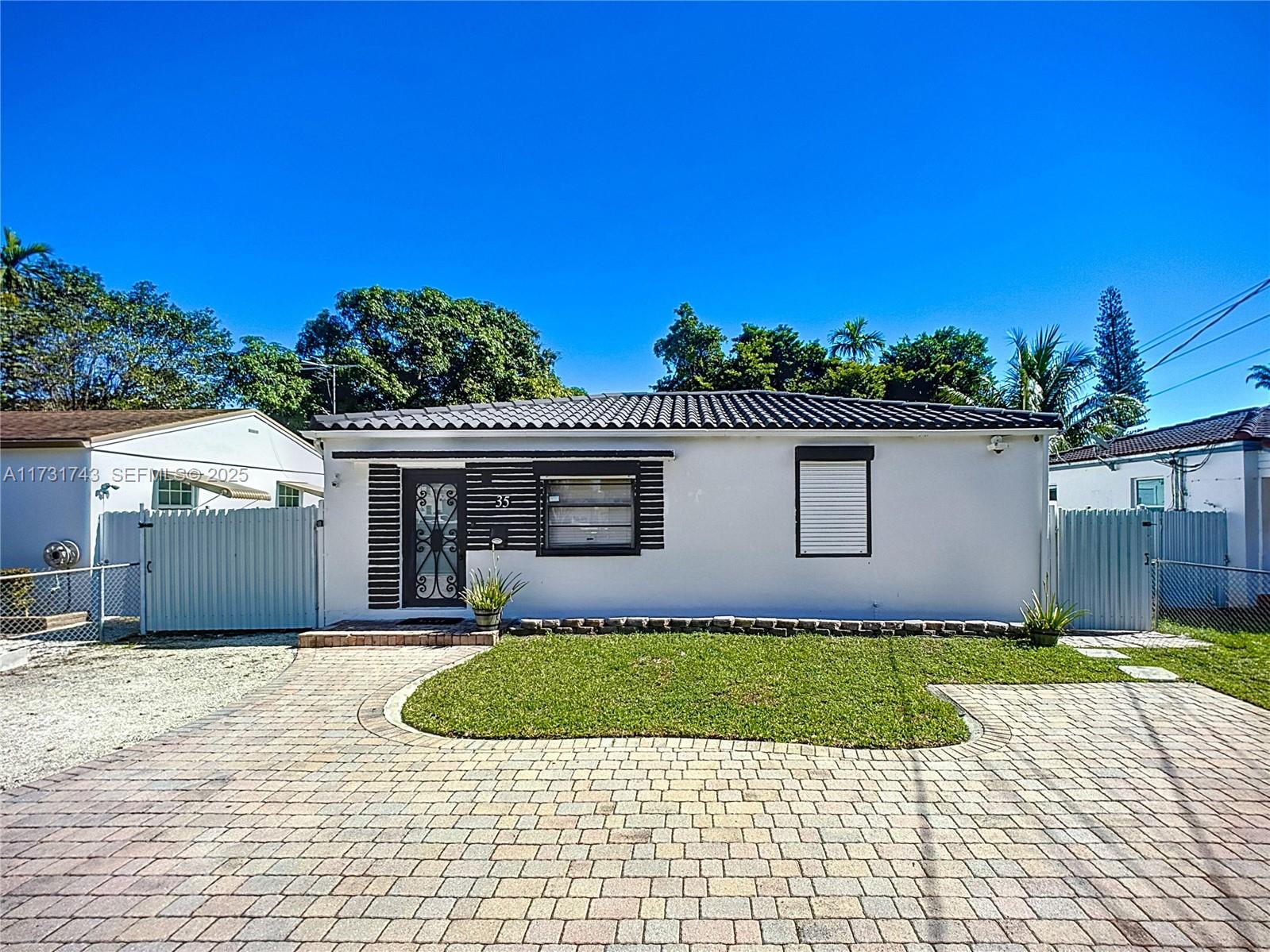 35 Southwest 63rd Court Miami, FL 33144 - Photo 5 of 42 a front view of a house with a yard and garage