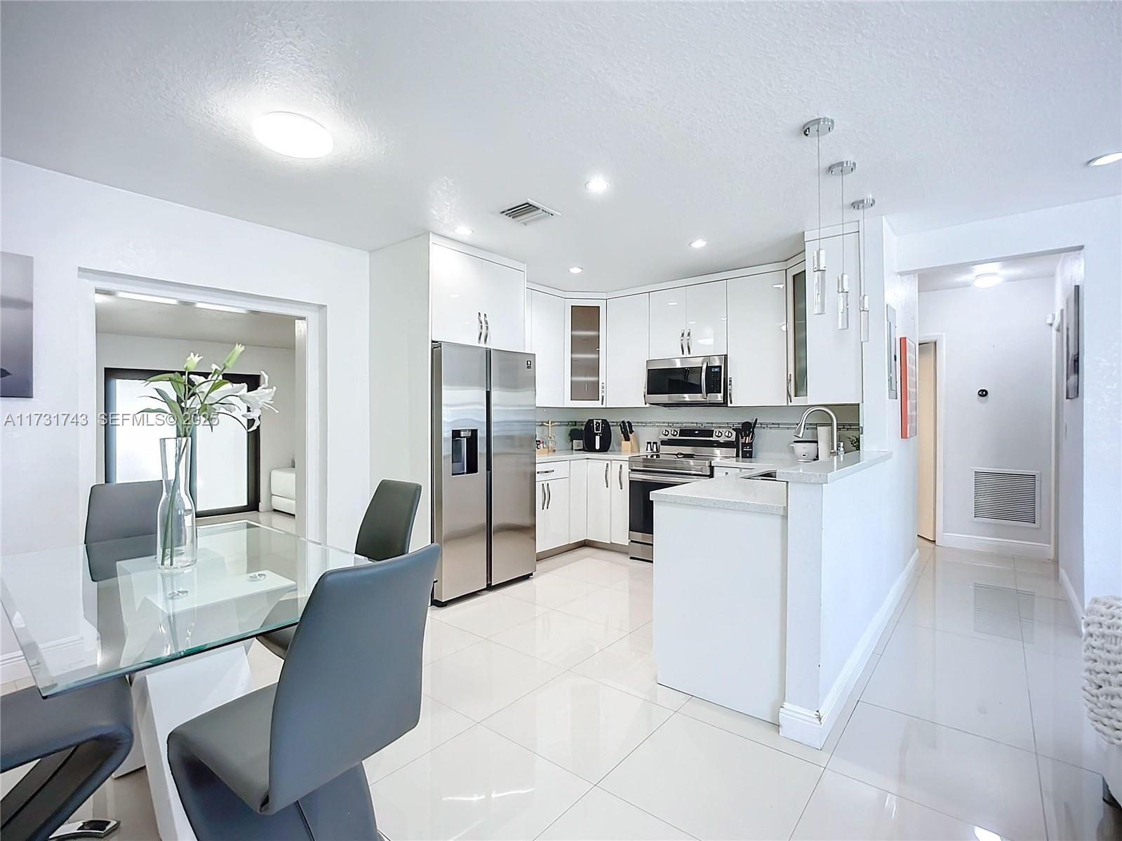35 Southwest 63rd Court Miami, FL 33144 - Photo 10 of 42 a kitchen with white cabinets and refrigerator