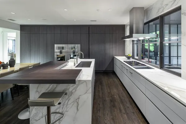 a kitchen with stainless steel appliances a table chairs in it and wooden floors