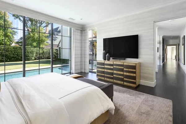 a bedroom with a bed and large windows