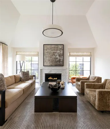 a living room with furniture a fireplace and a chandelier
