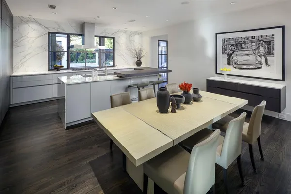 a kitchen with a table chairs and wooden floor