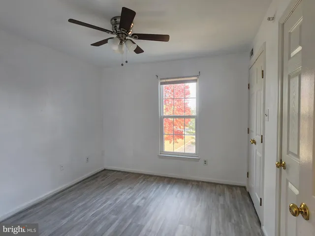 an empty room with a window and a ceiling fan