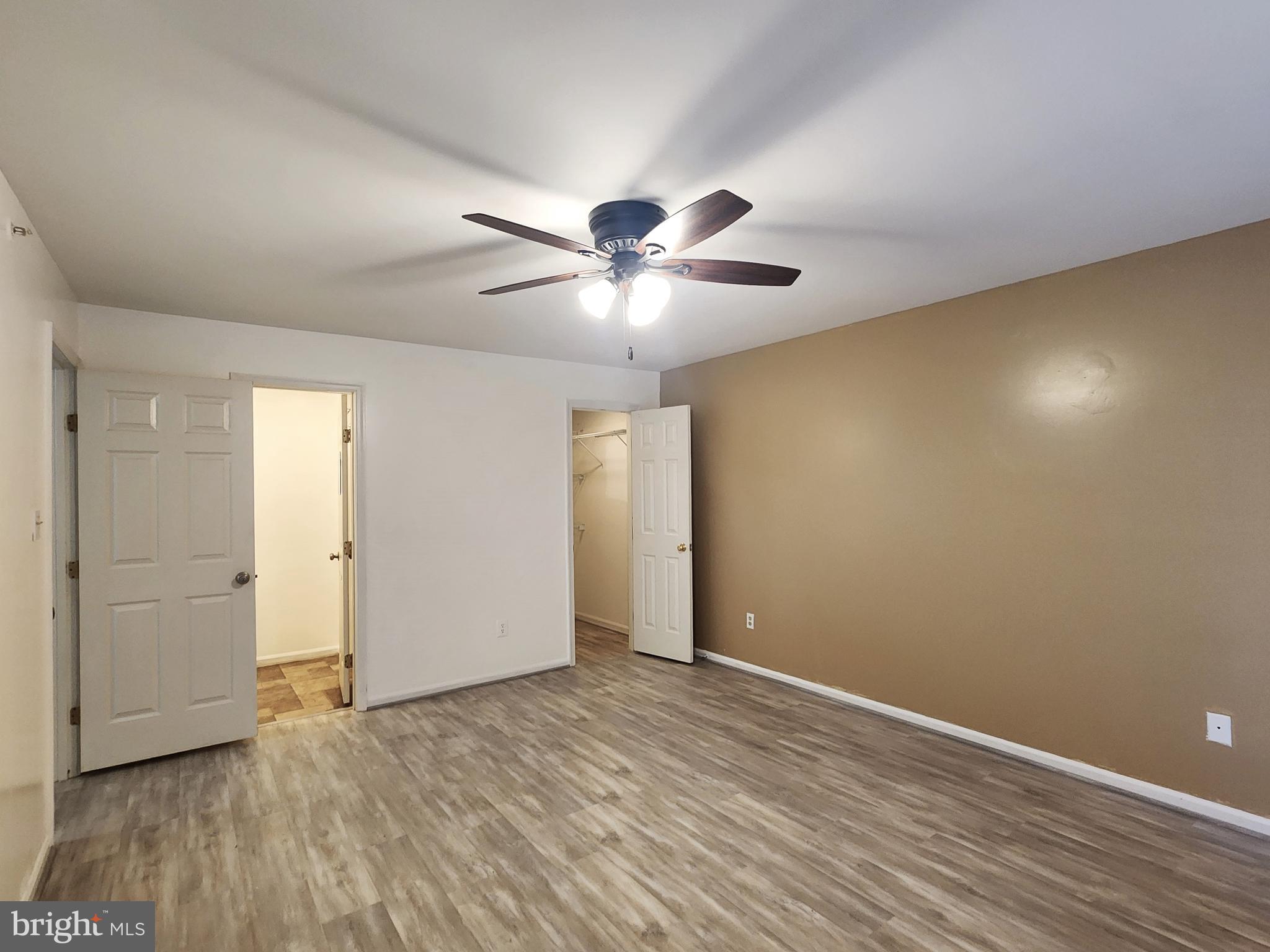 13 Locust Path Court, Unit 813 Nottingham, MD 21236 - Photo 20 of 23 an empty room with wooden floor and a ceiling fan