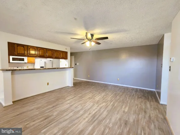 a view of a kitchen with wooden floor and a ceiling fan