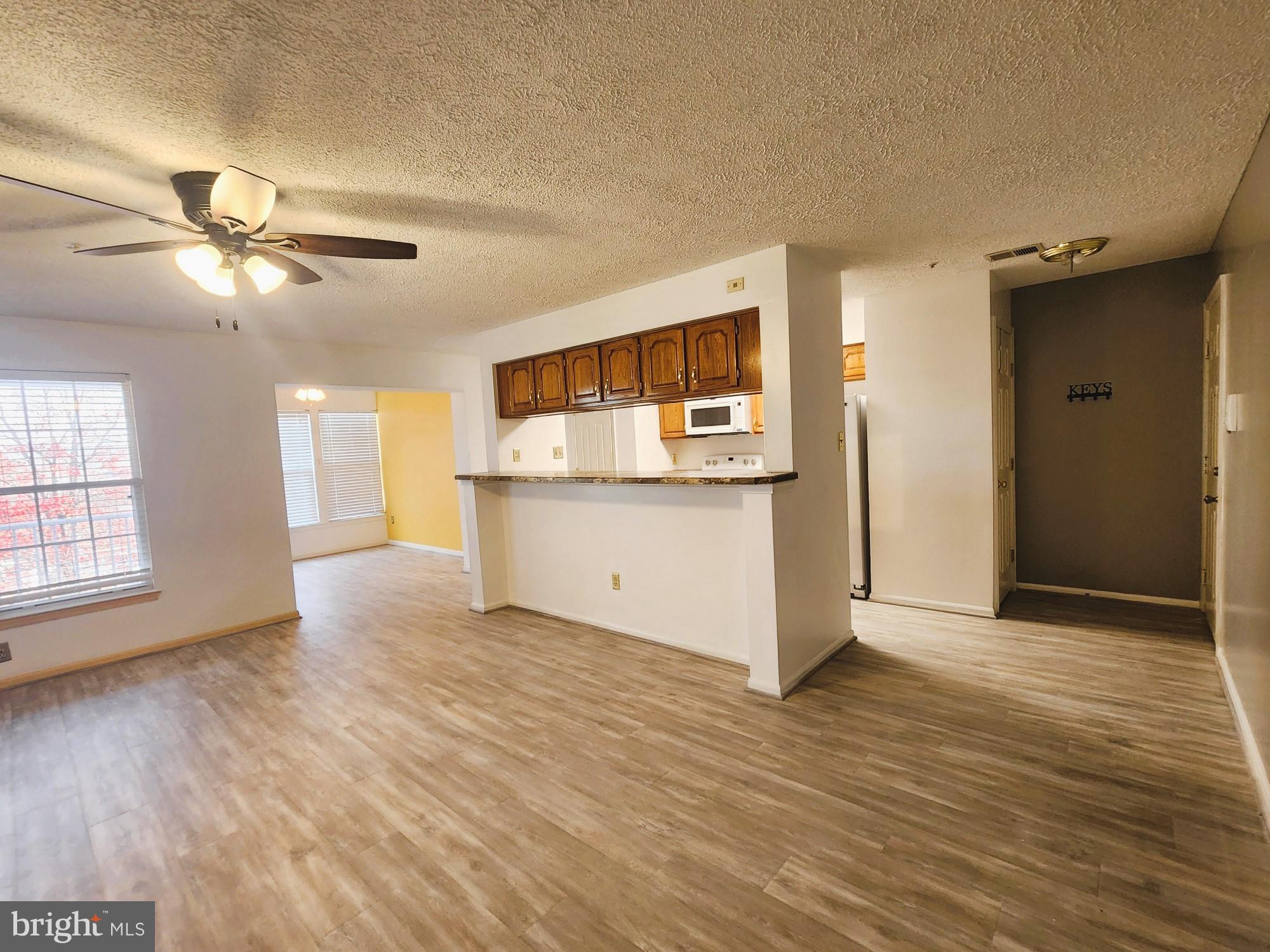 13 Locust Path Court, Unit 813 Nottingham, MD 21236 - Photo 5 of 23 a view of a kitchen with wooden floor and a ceiling fan
