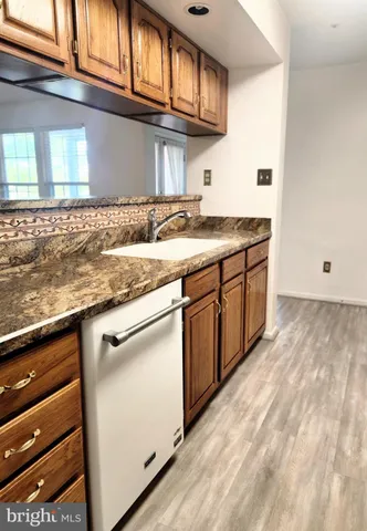 a kitchen with granite countertop stainless steel appliances a sink and cabinets