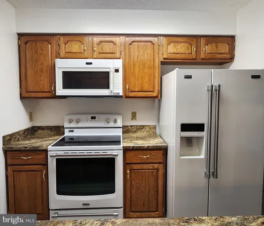 a kitchen with stainless steel appliances granite countertop a stove a microwave and a refrigerator
