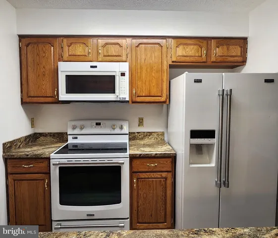 a kitchen with stainless steel appliances granite countertop a stove a microwave and a refrigerator
