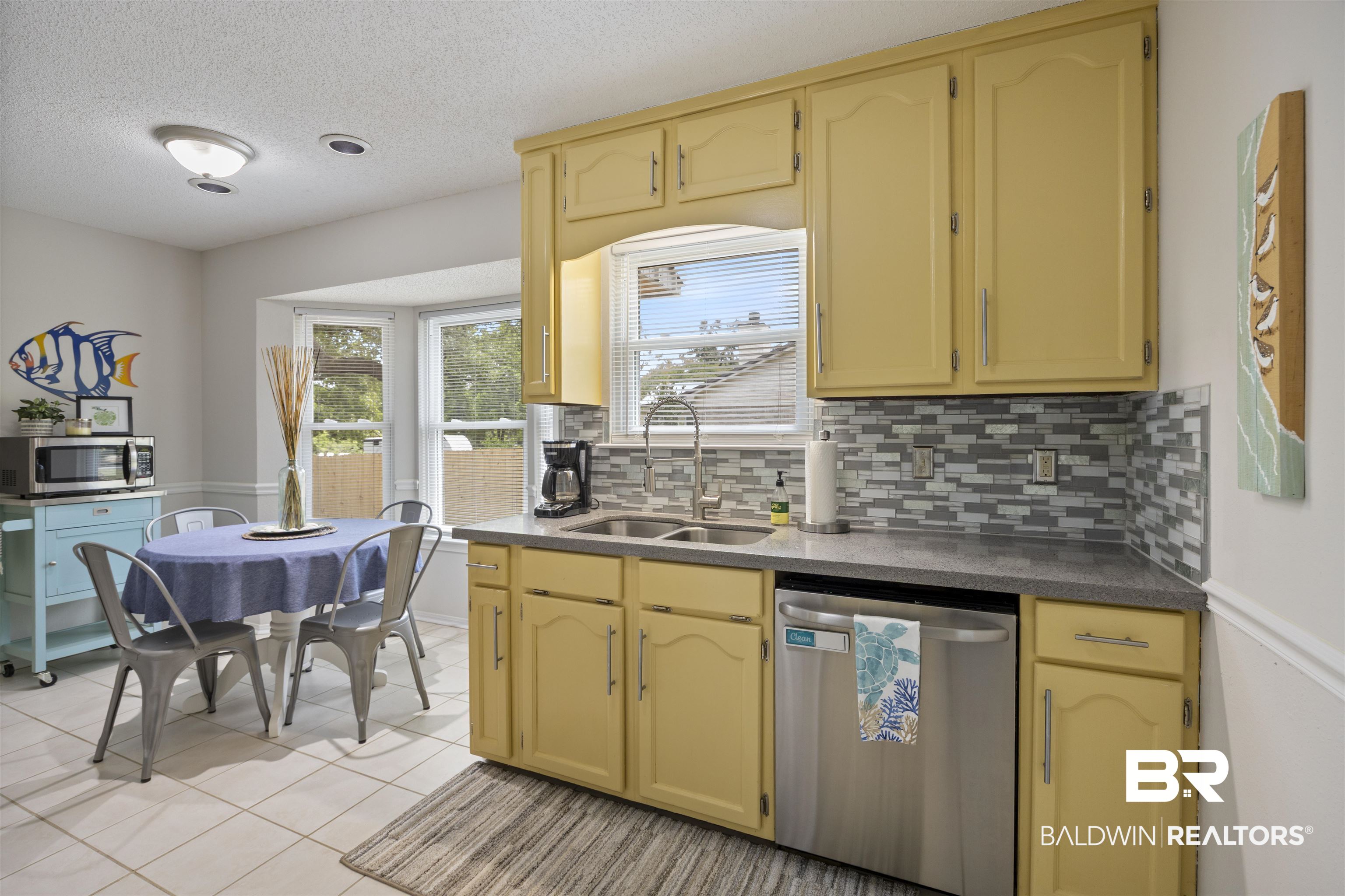 9771 Clarke Ridge Road Foley, AL 36535 - Photo 32 of 72 Kitchen with a textured ceiling, light tile patterned floors, a sink, stainless steel appliances, and tasteful backsplash.