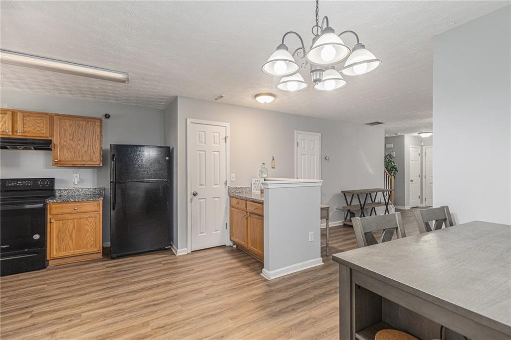 6536 Arbor Gate Drive Southwest, Unit 2 Mableton, GA 30126 - Photo 8 of 27 a kitchen with a refrigerator a sink dishwasher a stove and a refrigerator with wooden floor