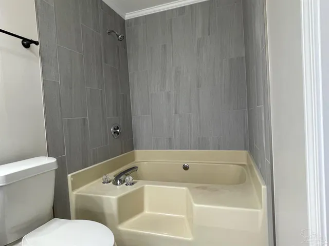 a white bath tub sitting next to a white toilet and sink
