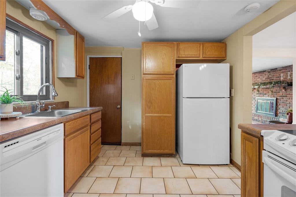 1670 Breining Street Pittsburgh, PA 15234 - Photo 16 of 39 a kitchen with a refrigerator sink and cabinets