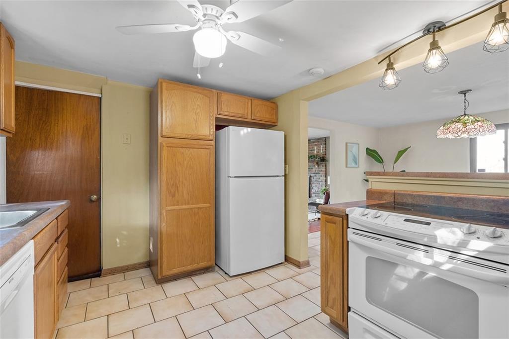 1670 Breining Street Pittsburgh, PA 15234 - Photo 17 of 39 a kitchen with a refrigerator a stove top oven and cabinets