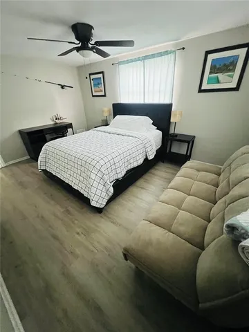 a bedroom with a bed couch and window